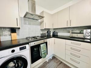 a kitchen with a washing machine and a washer at New!! Refurbished 4 Bedroom House in the Heart of Basildon I Weekly or Monthly Stay Offer I Free Parking I Sleeps 7 in Basildon