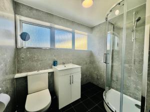 a bathroom with a toilet and a sink and a shower at New!! Refurbished 4 Bedroom House in the Heart of Basildon I Weekly or Monthly Stay Offer I Free Parking I Sleeps 7 in Basildon