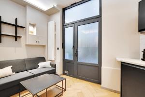 un salon avec un canapé et une porte dans l'établissement Pick A Flat's apartment in Champs-Elysées - Rue Marbeuf, à Paris
