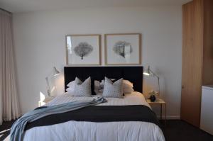 a bedroom with a large bed with two pictures on the wall at Blue Range Estate Villas in Rosebud