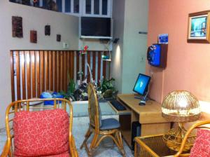 a room with a desk with a computer and chairs at Hotel Caribe in Santa Cruz de Barahona
