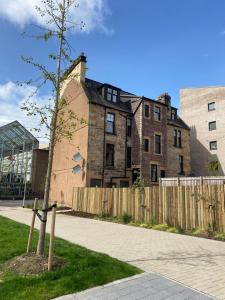a tree on a sidewalk in front of a building at 6 Smithhills - Sleeps 3 Central Excellent Transport Links Glasgow & Airport in Paisley
