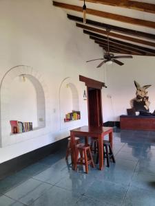 a table and chairs in a room with a ceiling at Poco a Poco Hostel in León