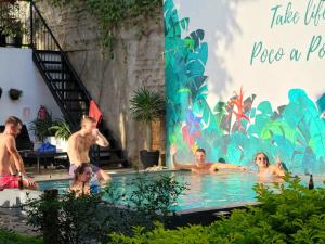 a group of people in a swimming pool at Poco a Poco Hostel in León
