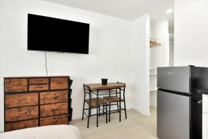 a kitchen with a dresser and a television on a wall at Cozy Studio Suite Near Beach W Kitchenette #5 in Daytona Beach Shores