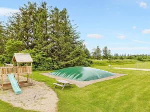 a small green pond with a gazebo and a bench at Seaside escape in Hanstholm- Type3 in Hanstholm