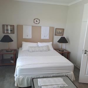 a bedroom with a large bed with a clock on the wall at Corgi Cottage in Stanford