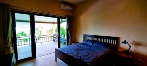 1 dormitorio con 1 cama y puerta a un balcón en Dream View Boutique Apartments - Sea View - Near Haad Yao, Secret Beach & Mae Haad, Koh Phangan, en Ko Pha Ngan