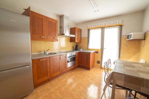 a kitchen with wooden cabinets and a stainless steel refrigerator at Aranaz bardenas in Cadreita