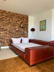 a bed in a room with a red leather couch at Deichoase bei Friesens mit Sauna in Barsfleth