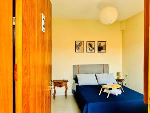 a bedroom with a bed with blue sheets and a table at Vila do Sol in Carrancas