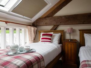 Un dormitorio con una cama con una bandeja encima. en Oliver Cromwell, en Winchcombe