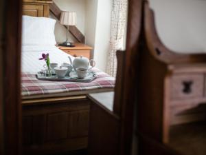 Una cama con dos tazas y una bandeja con flores. en Oliver Cromwell, en Winchcombe 16 fotos más