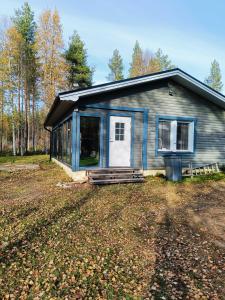a small blue house with a porch in a yard at Chalet Pellonranta 2 in Mäkituoma