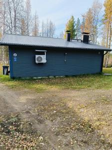 a blue building with a window and a roof at Chalet Pellonranta 2 in Mäkituoma +13 photos