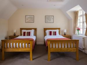 two beds in a room with two benches at Lord High Admiral in Winchcombe