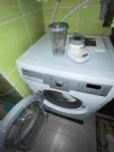 eine Waschmaschine mit einer Tasse darüber in der Unterkunft Apartment Wien in Wien