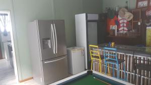 a kitchen with a refrigerator and a table and chairs at Porta Salutis in Port St Johns