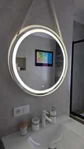 a bathroom with a mirror over a white sink at Galaxy Apartments 2 in Słupsk