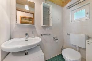 a white bathroom with a sink and a toilet at Chalet Laura al Passo della Mendola in Cavareno