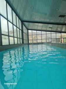 a swimming pool with blue water in a building with windows at Elegante depa de 2 dormitorios calacoto entre calle 9 y 10 in La Paz