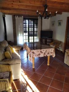 a living room with a table and a couch at Huerta Rocio in Linares de la Sierra