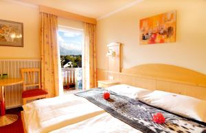 旧明斯特Panorama Hotel Traunstein的一间带床和大窗户的卧室