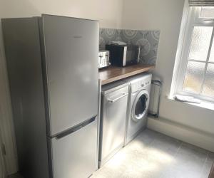 a kitchen with a refrigerator and a washer and dryer at Square View Grassington in Grassington