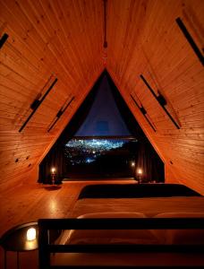 a bed in a wooden room with a window at Uptown Batumi Yard & Jacuzzi in Batumi