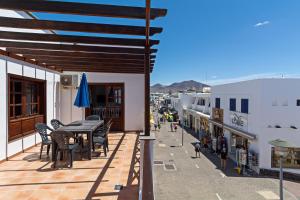 taras ze stołem i krzesłami na budynku w obiekcie Apartment Limonade Deluxe Main Center Playa Blanca By PVL w mieście Playa Blanca