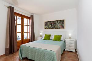 sypialnia z łóżkiem z zielonymi poduszkami i oknem w obiekcie Apartment Limonade Deluxe Main Center Playa Blanca By PVL w mieście Playa Blanca