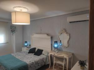 una camera da letto con un letto, un tavolo e uno specchio di CENTRO HISTORICO a Manzanares
