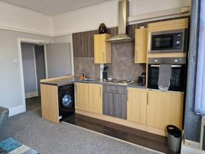 a kitchen with wooden cabinets and a washer and dryer at Levy Nook 10 in Darlington