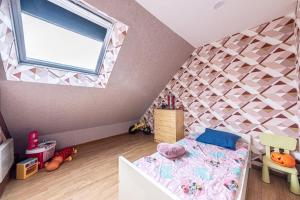 a childs bedroom with a bed and a window at Maison Proche Disney/Paris in Couilly-Pont-aux-Dames