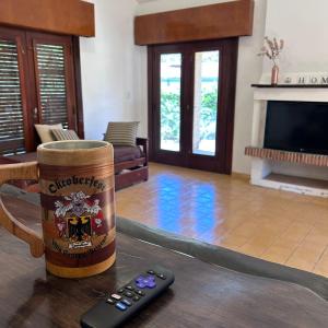 control remoto sentado en una mesa en una sala de estar en Amplia casa a solo unos metros del centro - RentVGB, en Villa General Belgrano