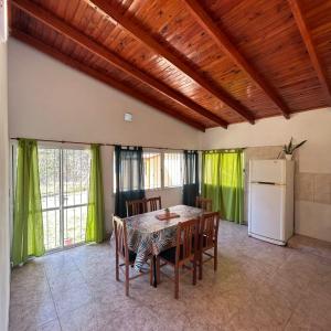 comedor con mesa, sillas y nevera en Amplia casa a solo unos metros del centro - RentVGB, en Villa General Belgrano