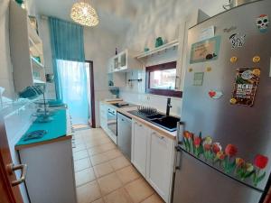 a kitchen with a refrigerator with flowers on it at Villa KITE KATE, cozy space, house and garden in La Oliva +17 photos