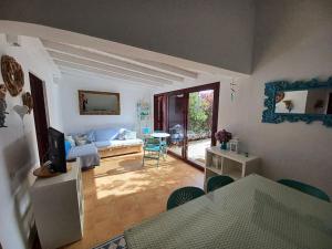 a living room with a bed and a television at Villa KITE KATE, cozy space, house and garden in La Oliva