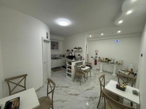 a kitchen with tables and chairs and a refrigerator at B&B A un passo dal mare in Crotone