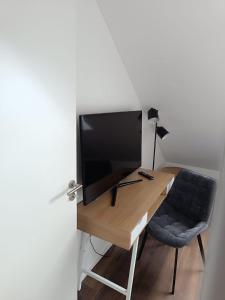 a room with a desk with a television and a chair at Moderne Ferienwohnung für Familien im Dachgeschoss in Bosau