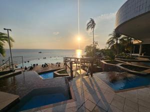 a view of a resort with a pool and the ocean at Tropical Executive Luxuoso Vista pro Rio in Manaus
