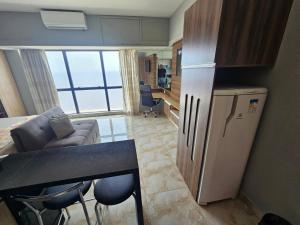 a kitchen with a refrigerator and a table in a room at Tropical Executive Luxuoso Vista pro Rio in Manaus