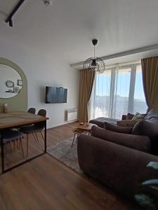 科帕奥尼克Apartman TRAMONTO Kopaonik的客厅里有一张沙发和一张桌子。