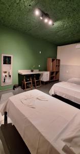a bedroom with two beds and a green wall at Agualinda Hotel in Alter do Chao +74 photos