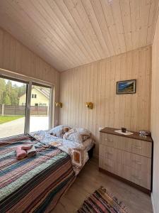 a bedroom with a bed and a dresser and a window at Villa Vlada in Saulkrasti +14 photos