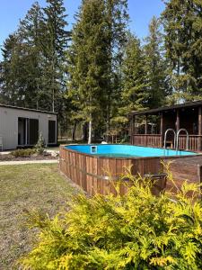 a house with a swimming pool in a yard at Villa Vlada vacation houses in Saulkrasti +28 photos