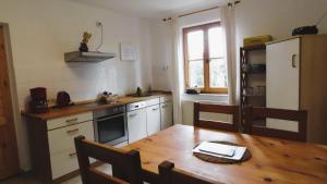 a kitchen with a wooden table and a refrigerator at Ferienwohnung "Specker Krug" in Kargow