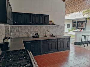 a kitchen with black cabinets and a sink at Poco a Poco Junior in León