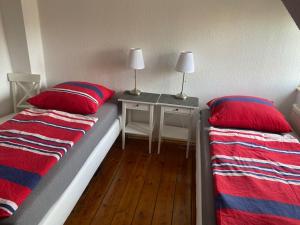 a bedroom with two beds and a table with two lamps at Schöne Wohnung zentrumsnah in Greifswald