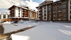 バンスコにあるApartments Belvedere B303の建物前の雪屋根付き駐車場